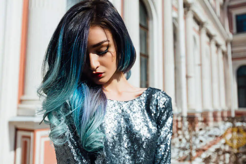 Fashion portrait of a gorgeous girl with blue dyed curly hair long