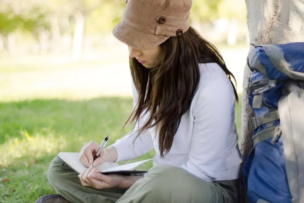 Woman writing on her travel journal 
